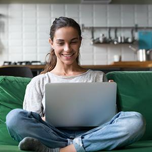 Women sitting on green couch with laptop open